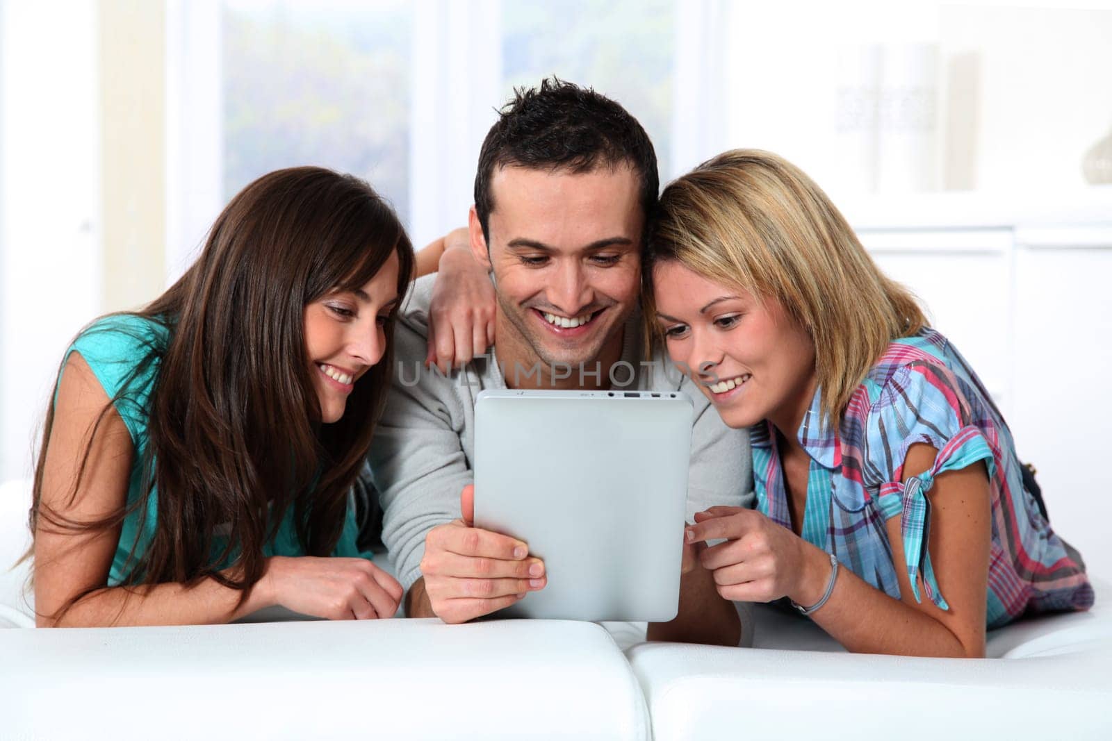 Group of friends laying in sofa at home