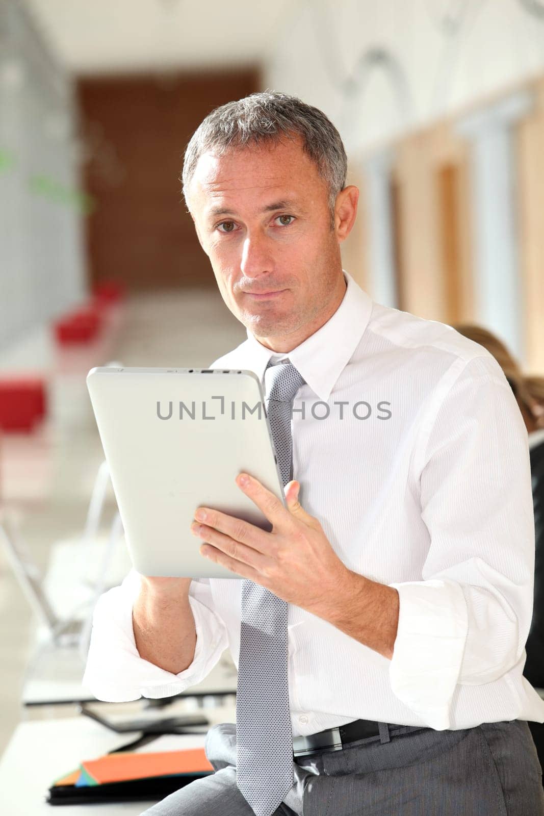 Office worker looking at internet on electronic pad