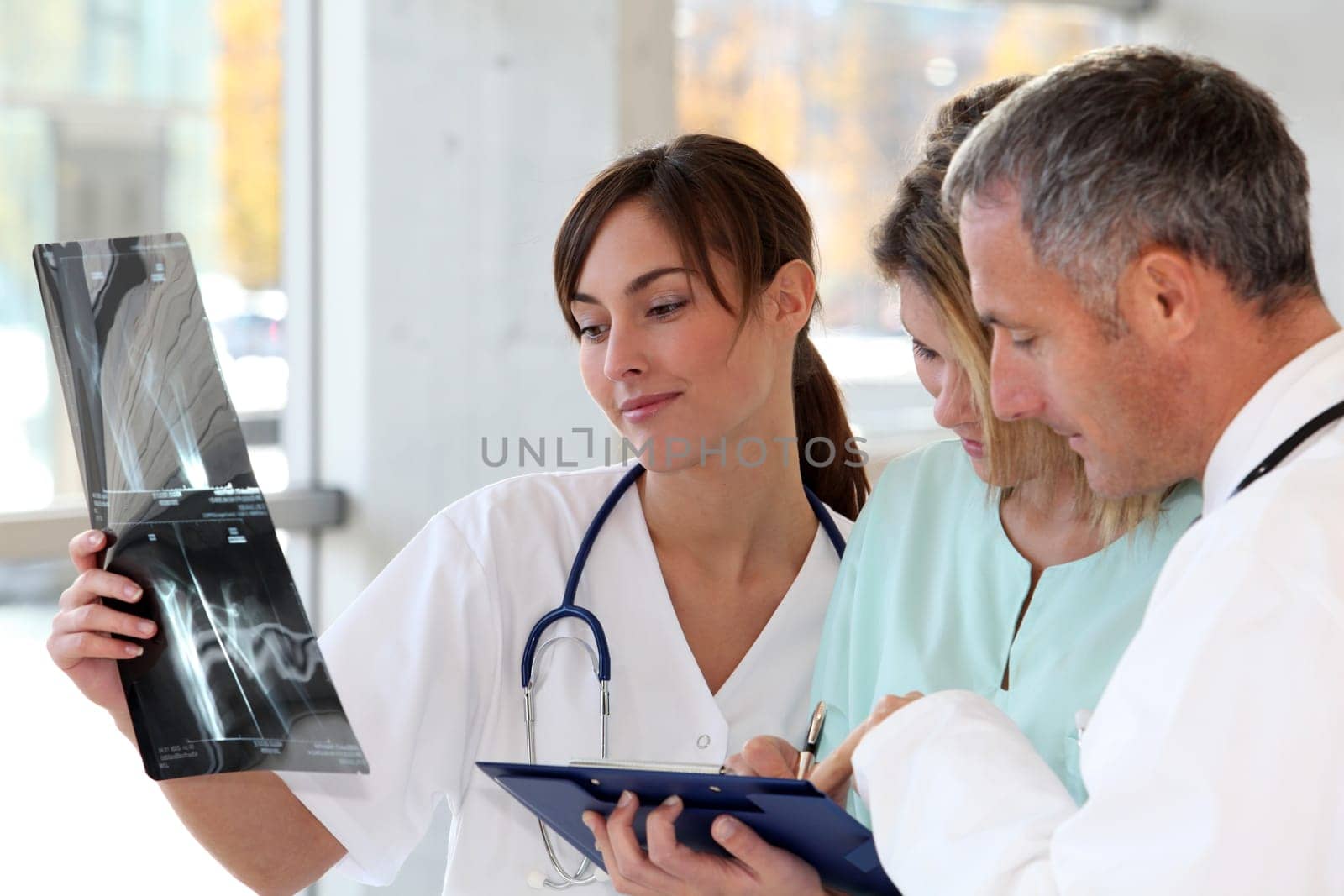 Medical team with handicapped person looking at X-ray