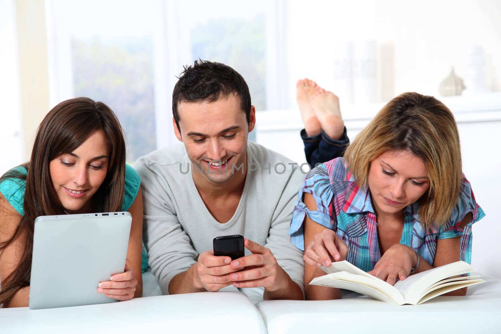 Group of friends laying in sofa at home