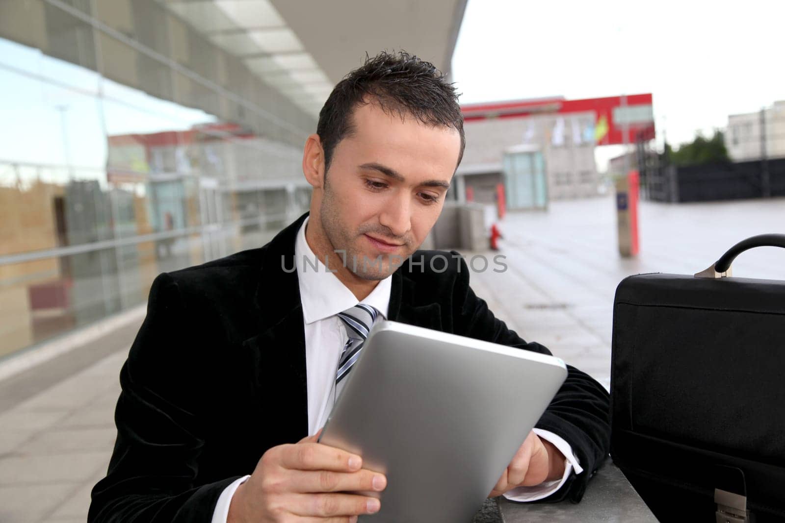 Salesman stading oustide with electronic tablet
