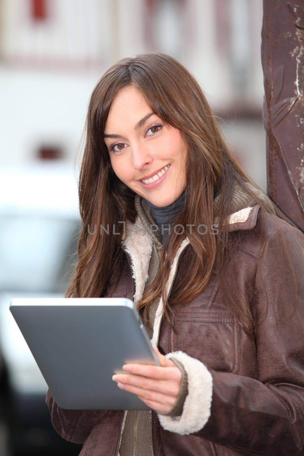 Young woman using electronic pad in town