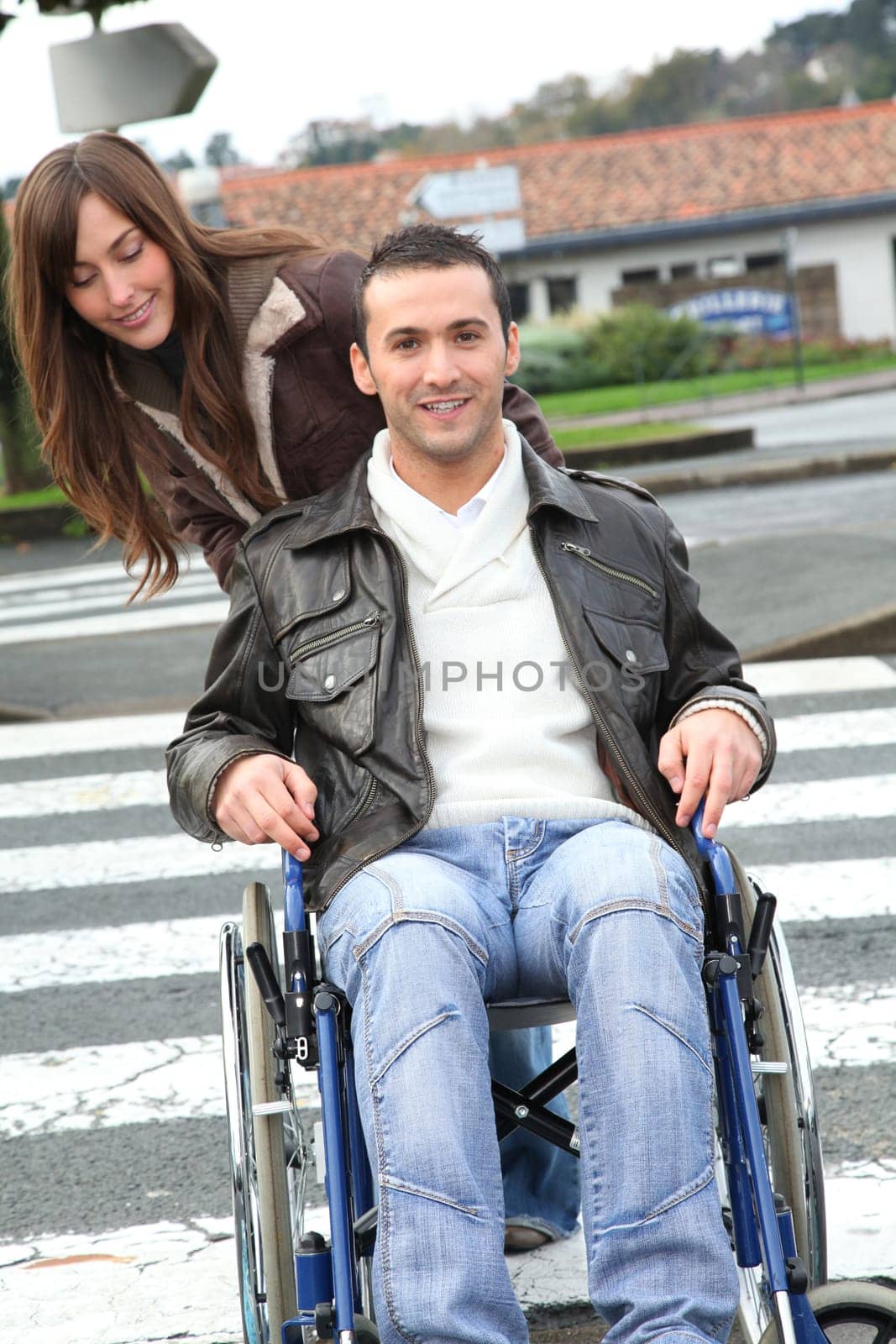 Woman helping friend in wheelchair cross the street