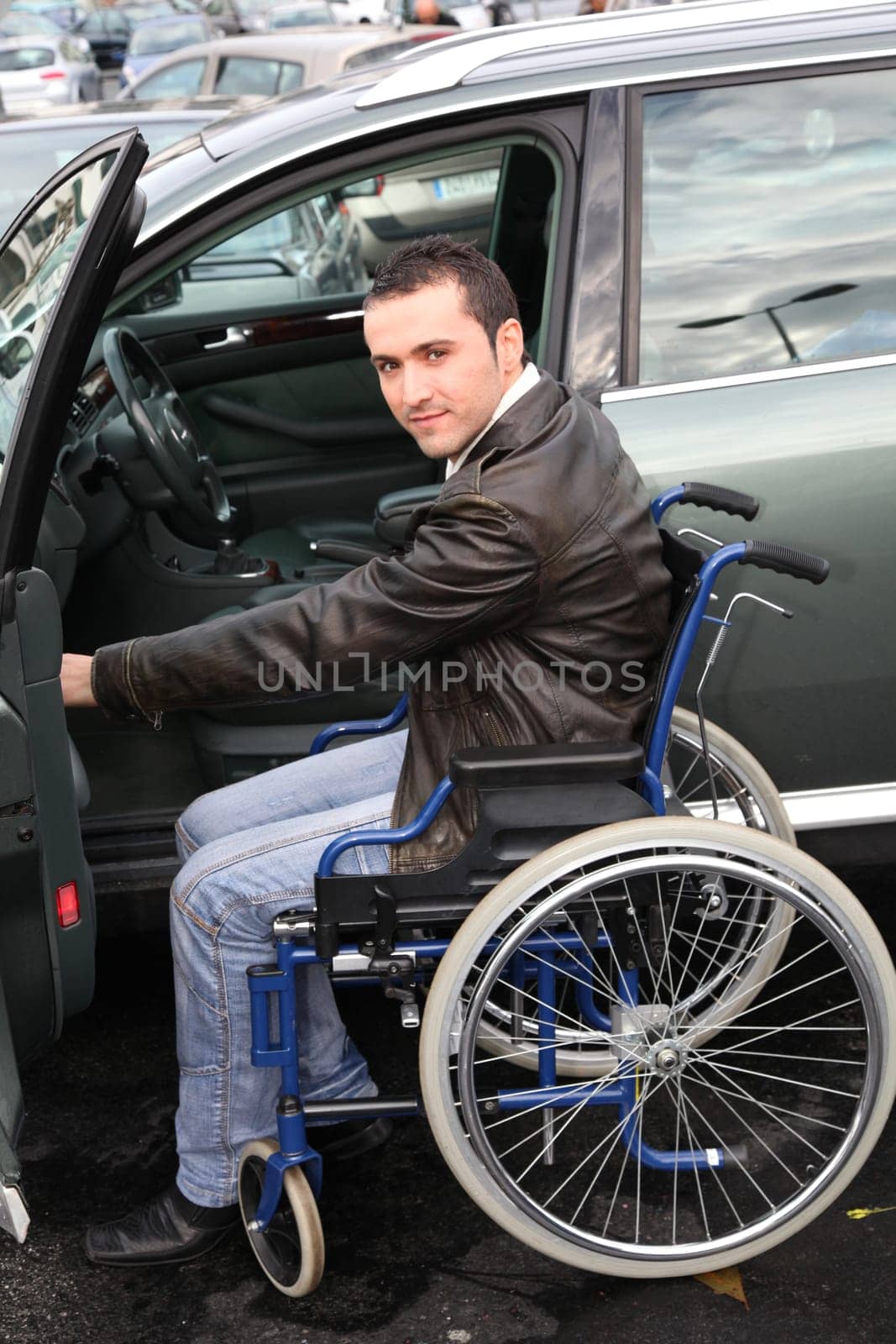 Young man in wheelchair getting in his car