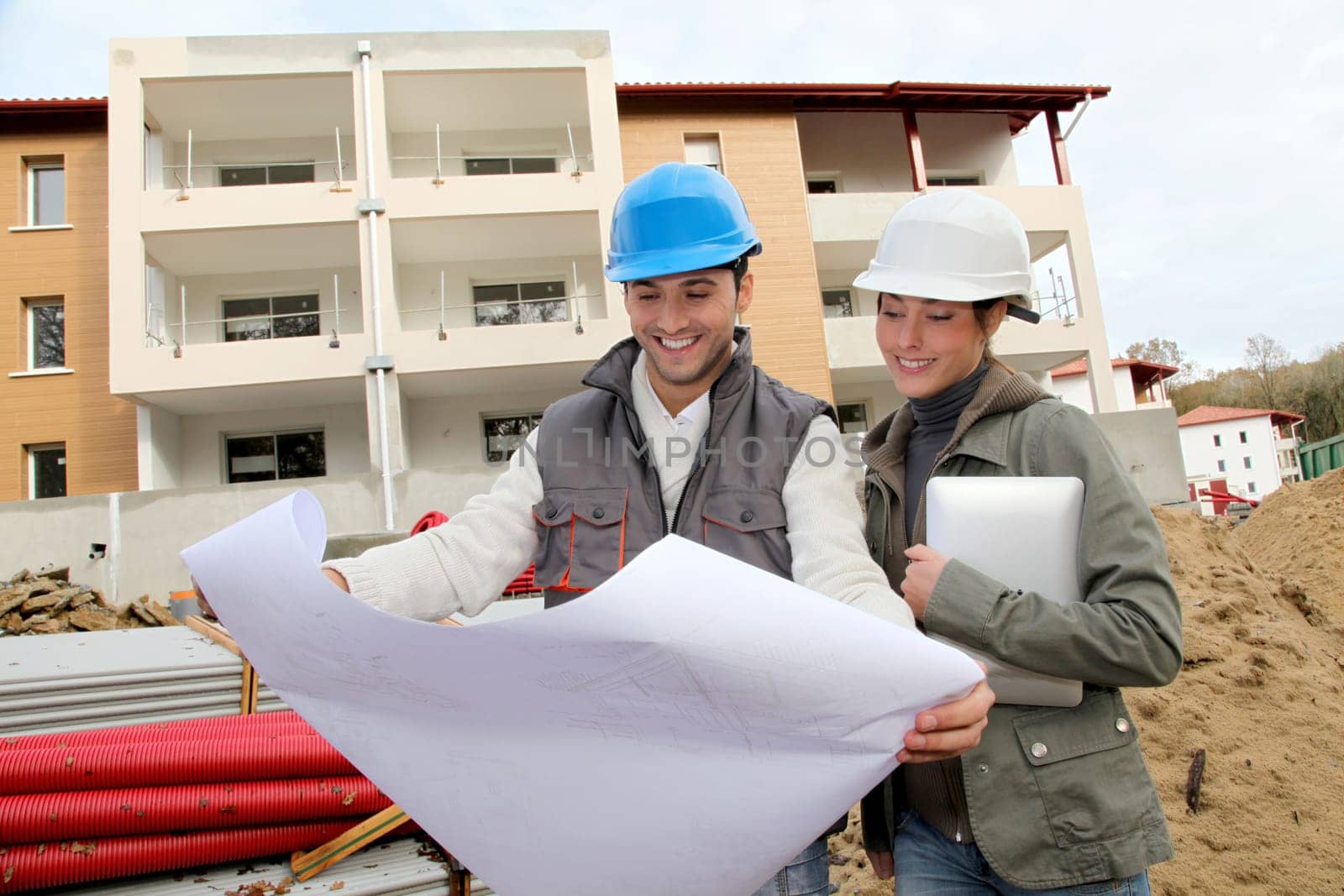 Architect and engineer looking at plan on construction site