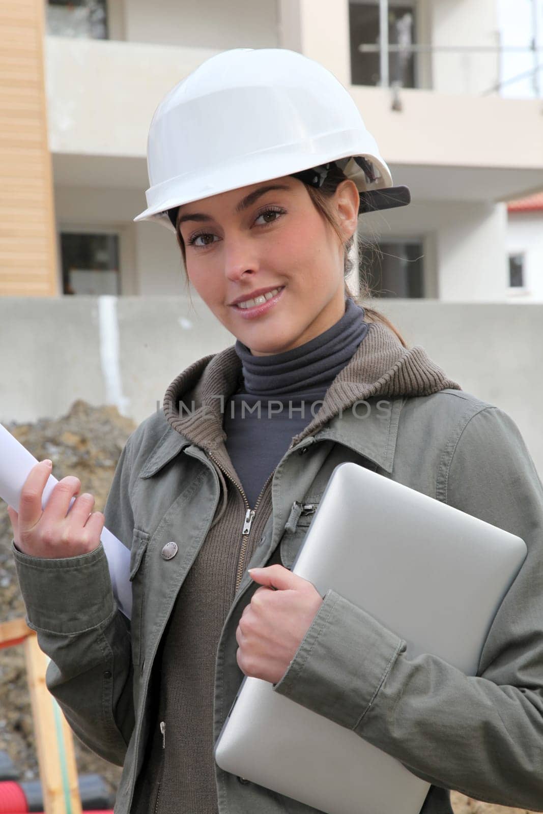 Woman engineer with white security helmet standing on construction site