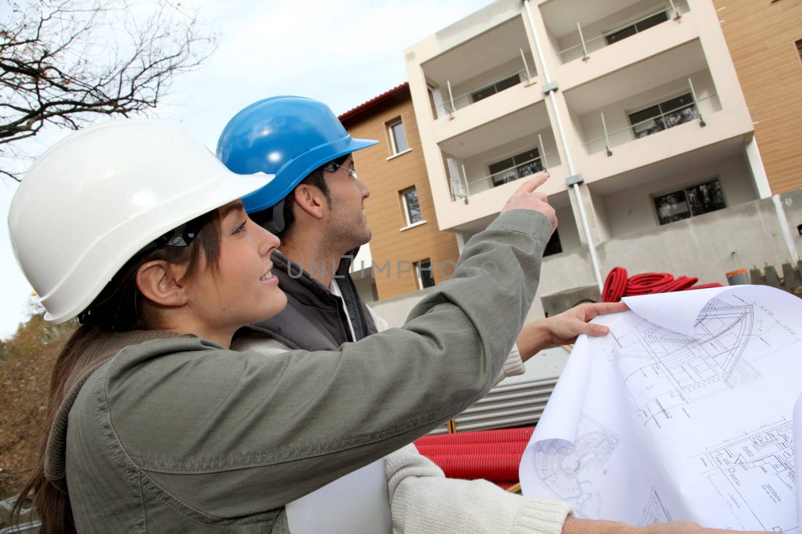 Architect and engineer looking at plan on construction site