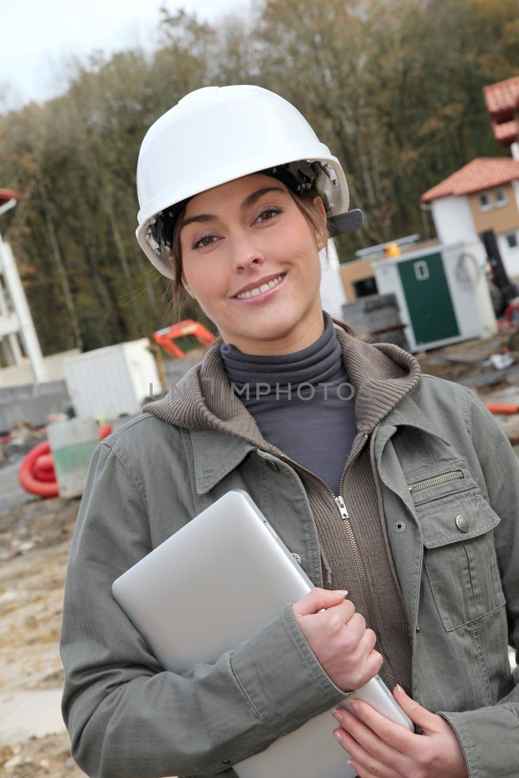 Woman engineer with white security helmet standing on construction site