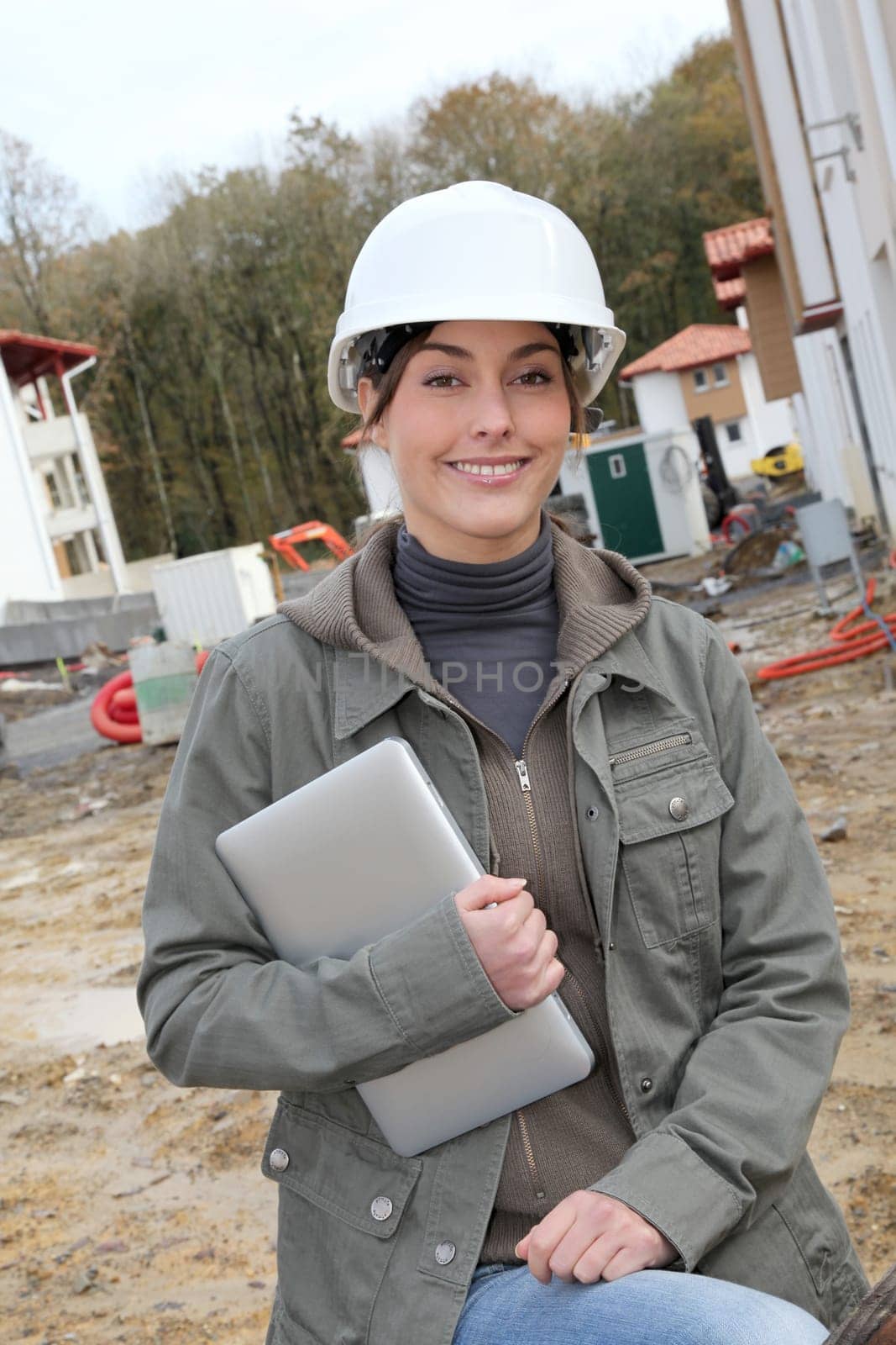 Woman engineer with white security helmet standing on construction site