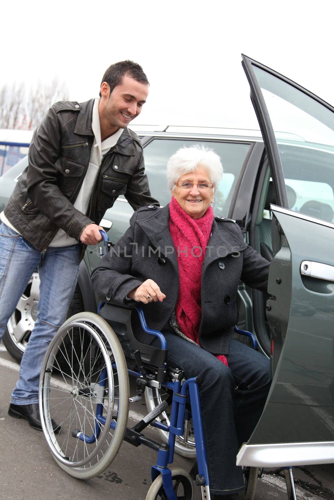 Young man assisting senior woman in wheelchair