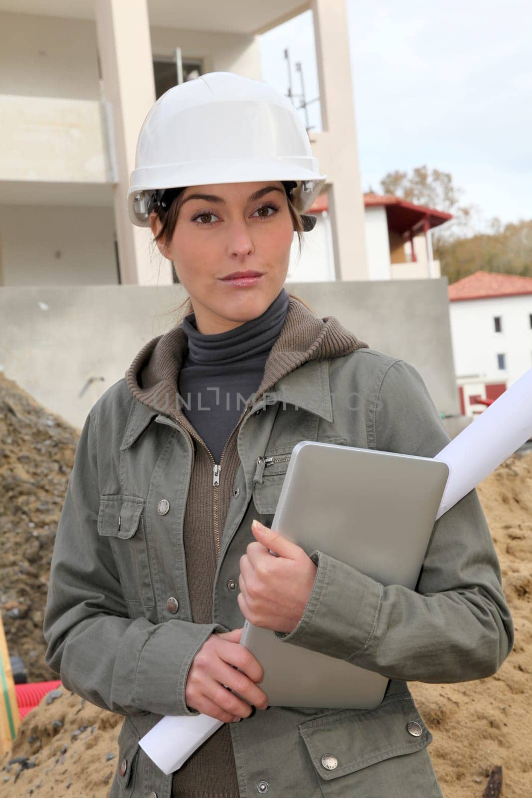 Woman engineer with white security helmet standing on construction site