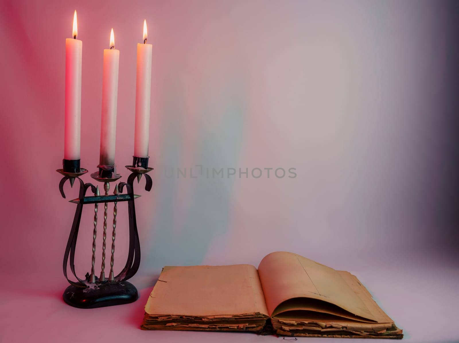 Elegant antique candelabrum with three lit candles, casting a warm glow on a red and purple gradient background. Perfect for romantic, gothic, and vintage-themed designs