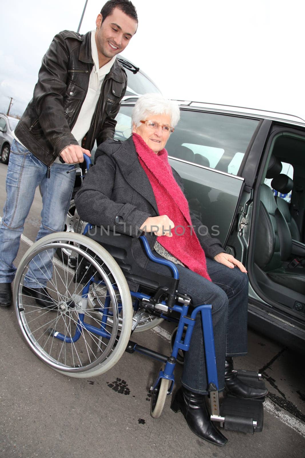 Young man assisting senior woman in wheelchair