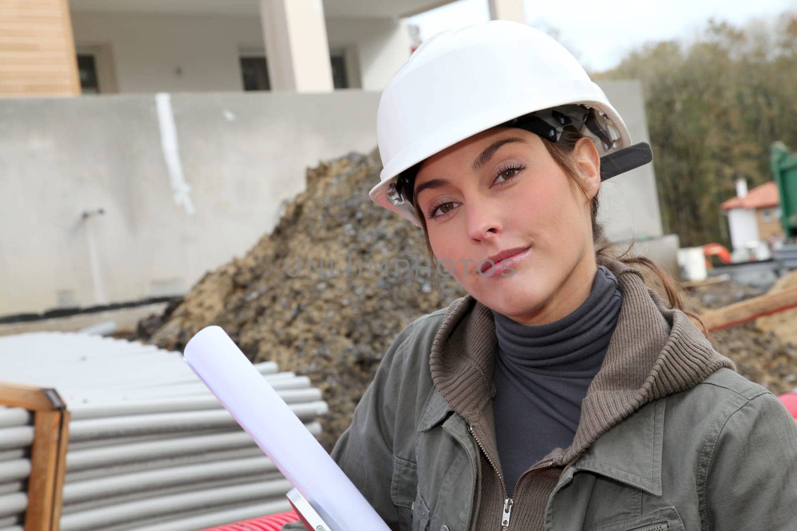Woman engineer with white security helmet standing on construction site