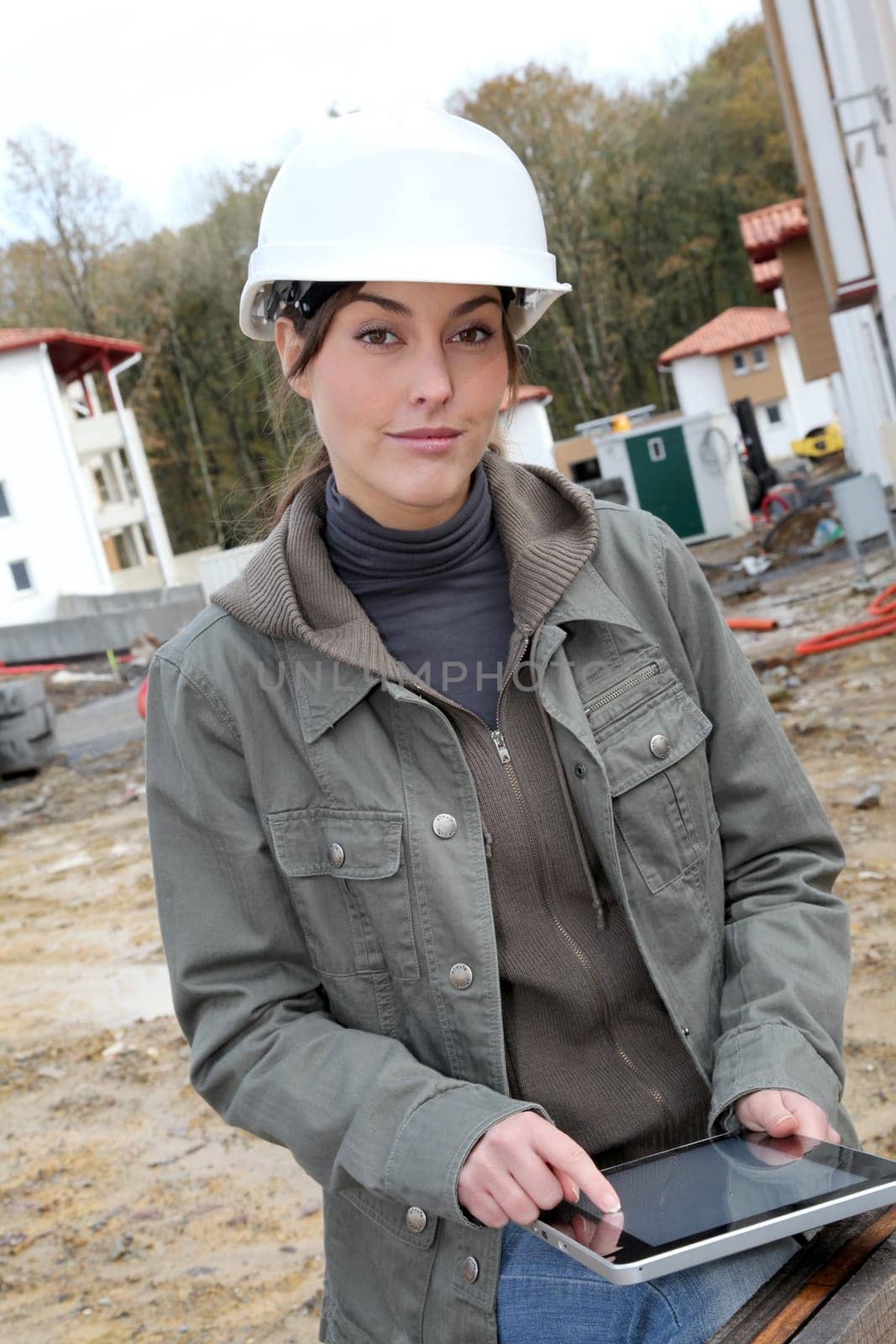 Woman engineer with white security helmet standing on construction site