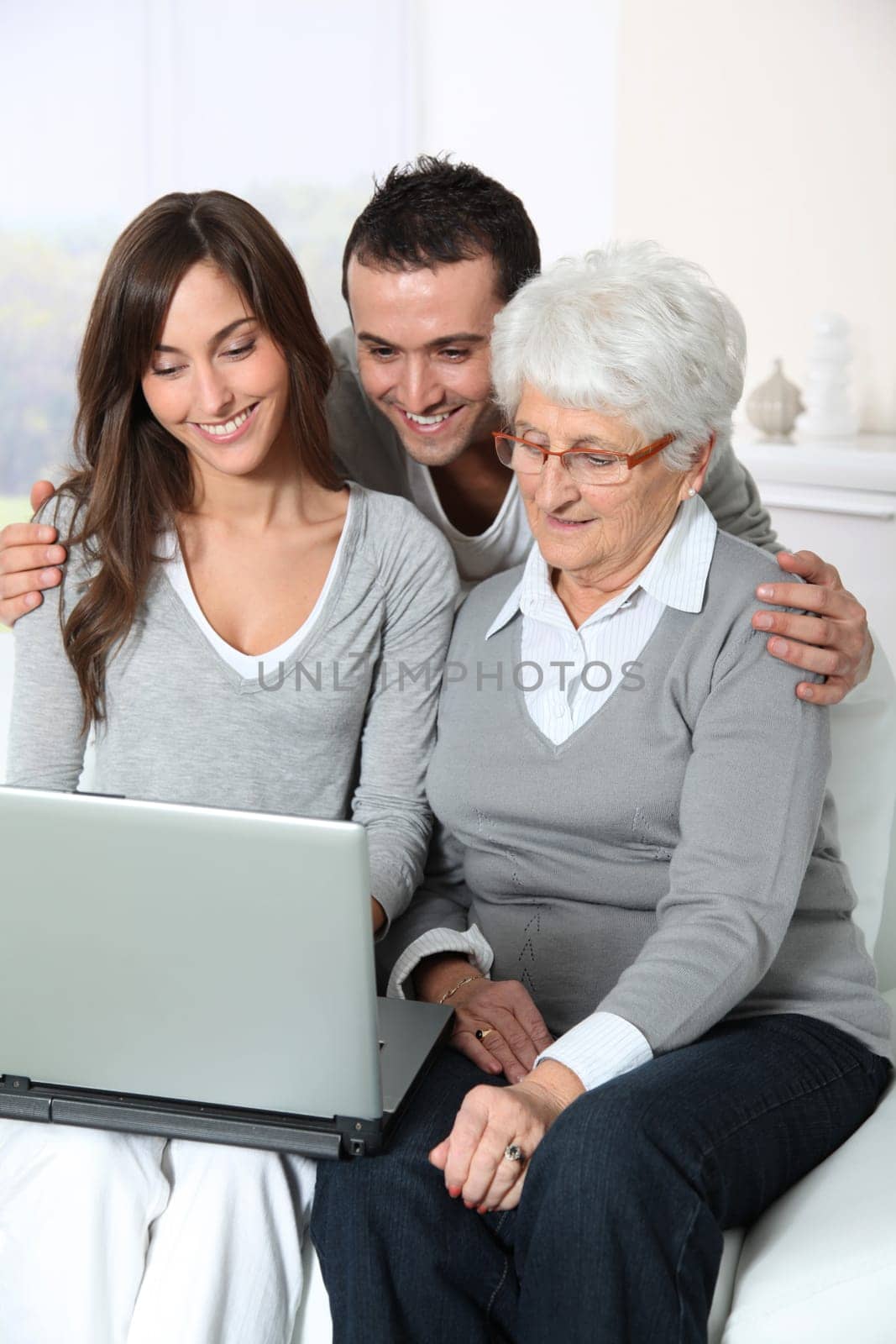 Elderly woman with grandchildren looking at laptop computer