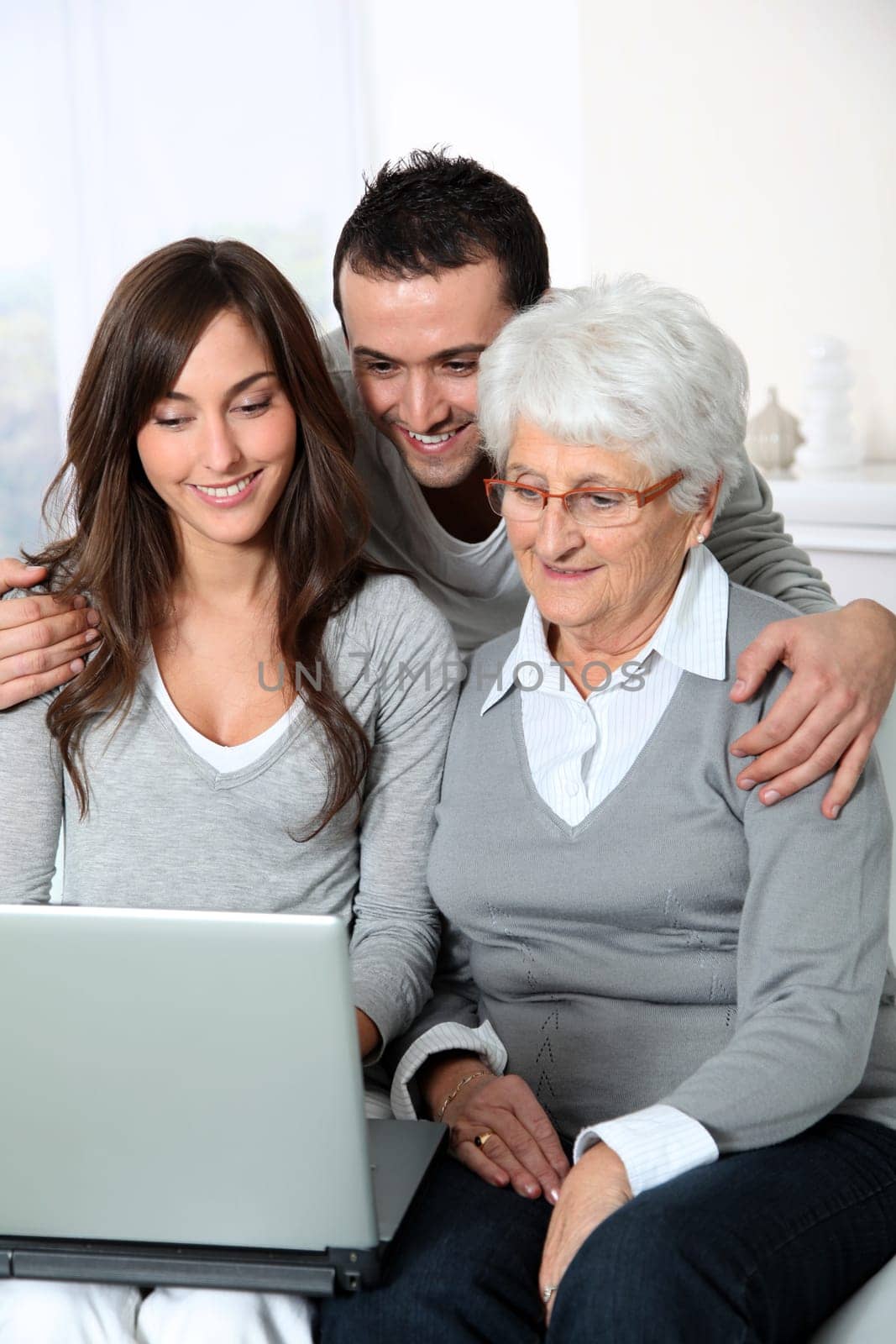 Elderly woman with grandchildren looking at laptop computer