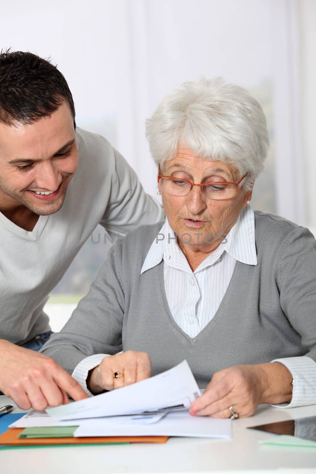 Young man helping elderly woman with paperwork