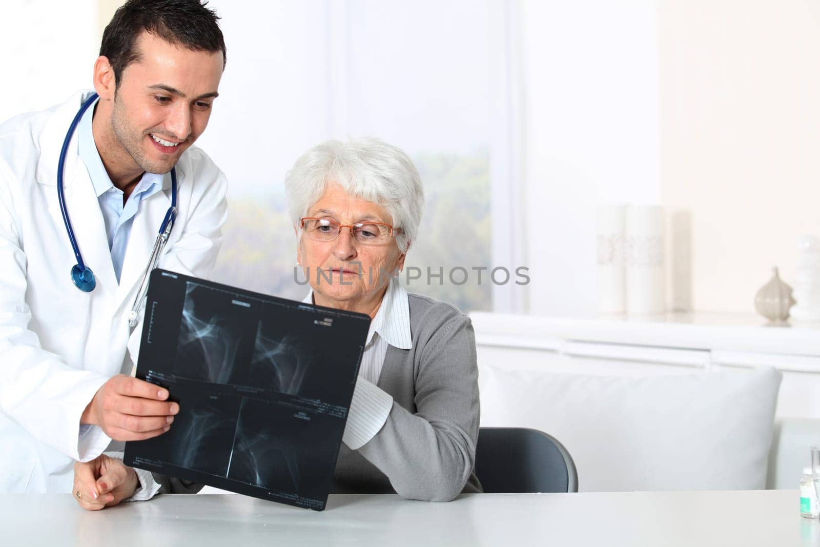 Doctor showing x-ray results to elderly woman