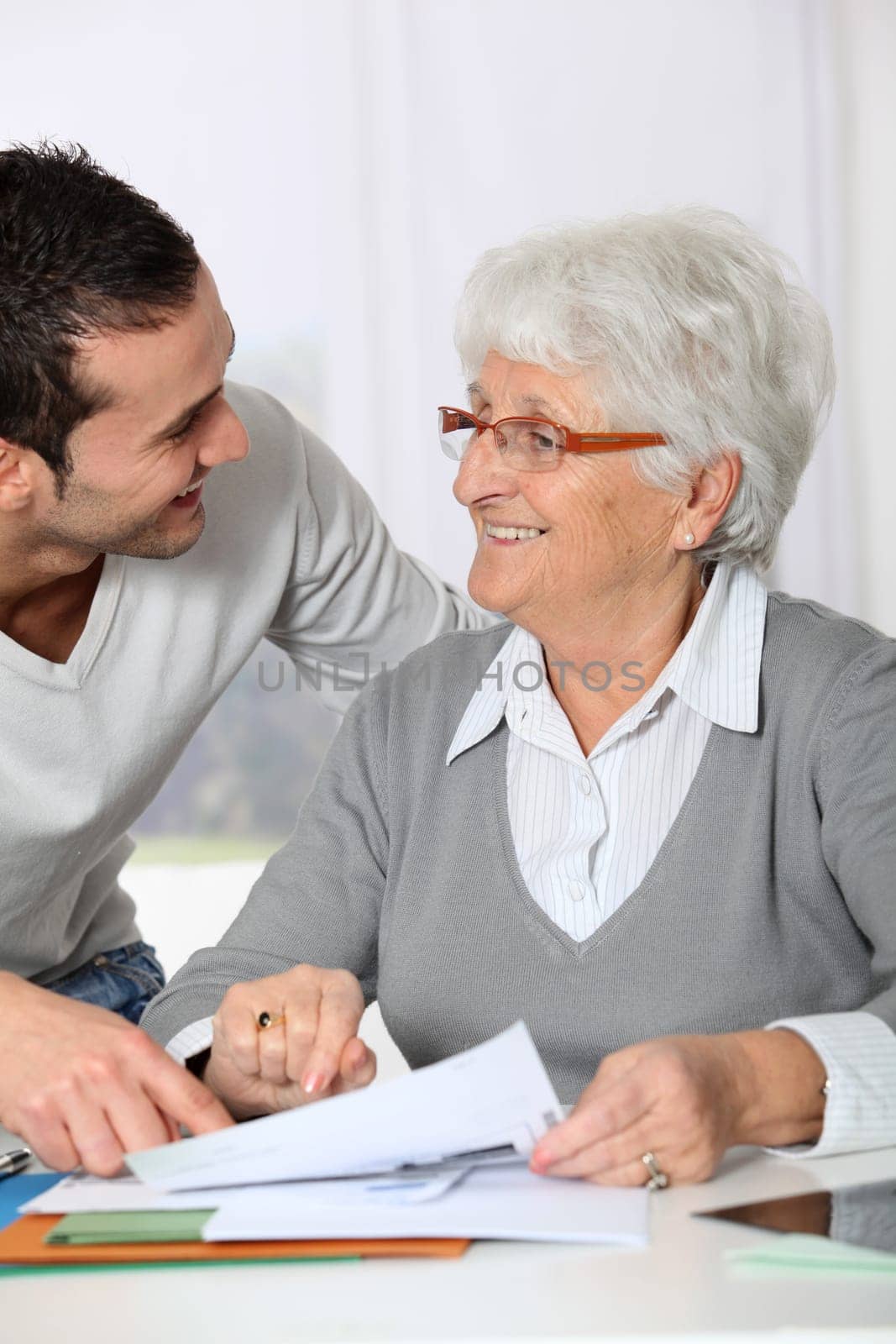 Young man helping elderly woman with paperwork