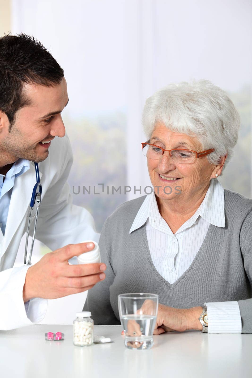 Doctor explaining drugs prescription to elderly woman