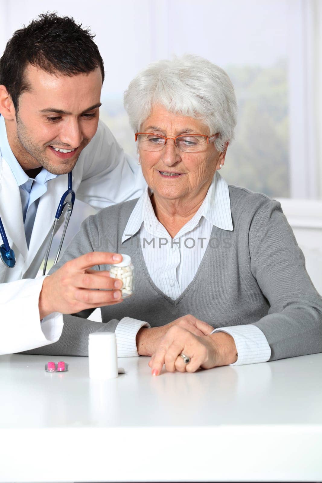 Doctor explaining drugs prescription to elderly woman