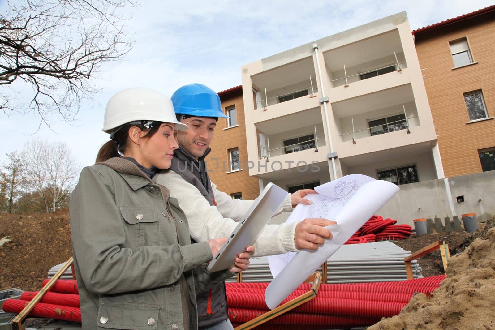 Architect and engineer looking at plan on construction site