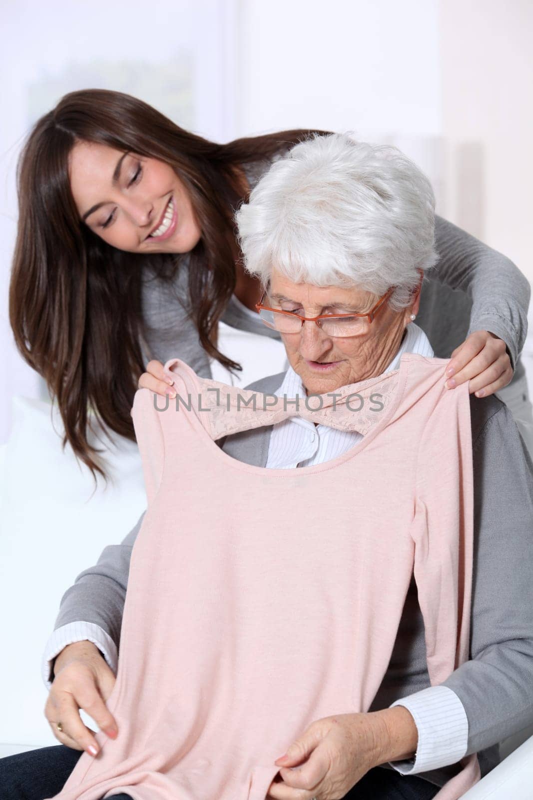 Young woman showing new clothes to grandmother