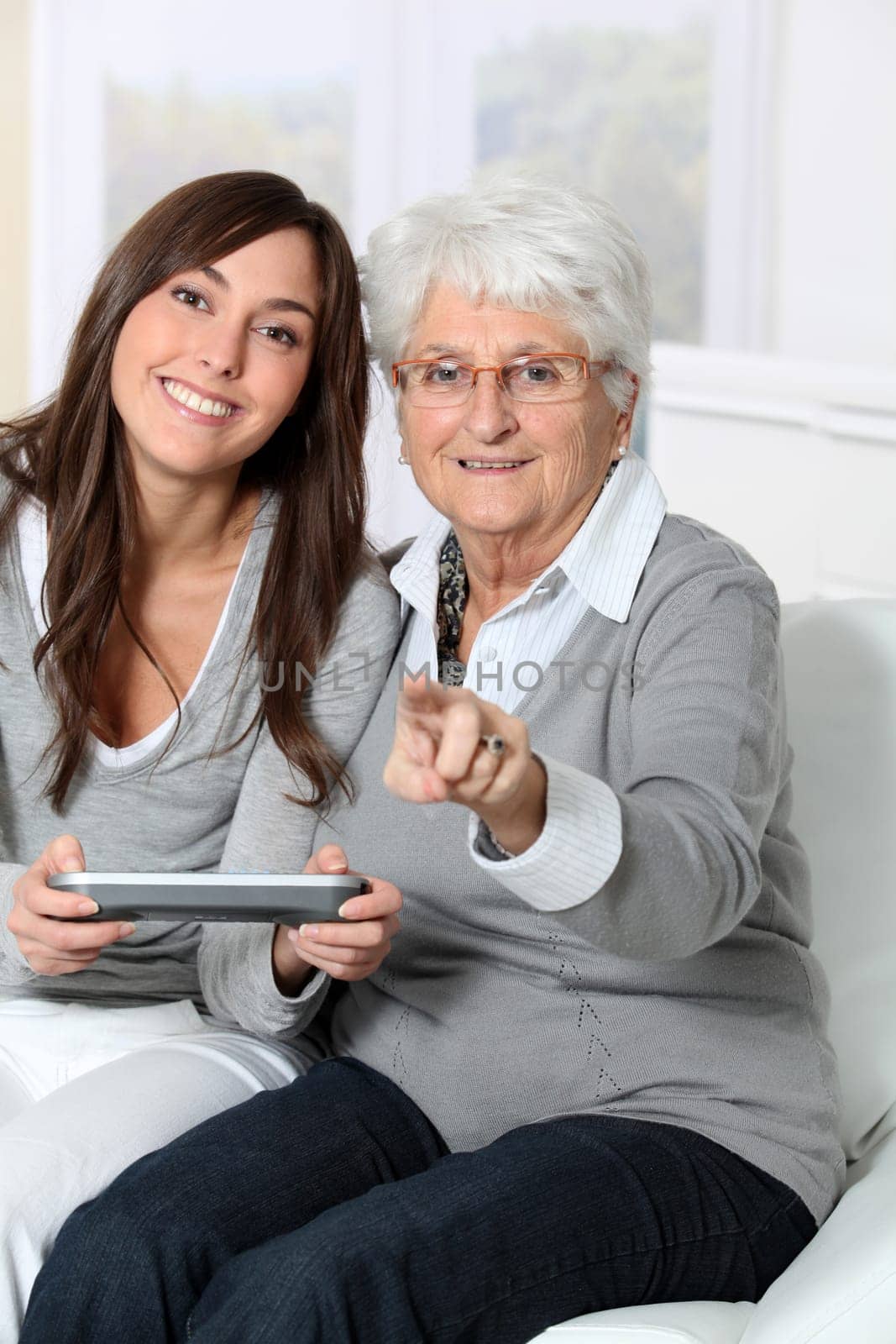 Young woman playing video game with grandmother