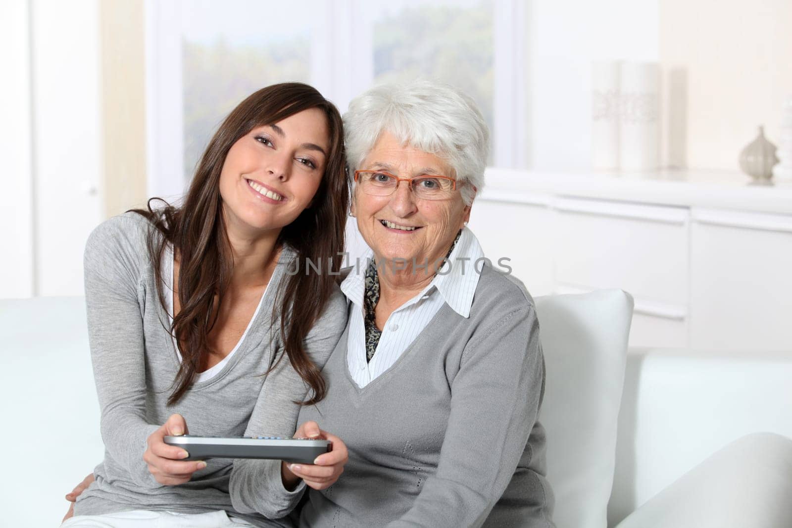 Young woman playing video game with grandmother