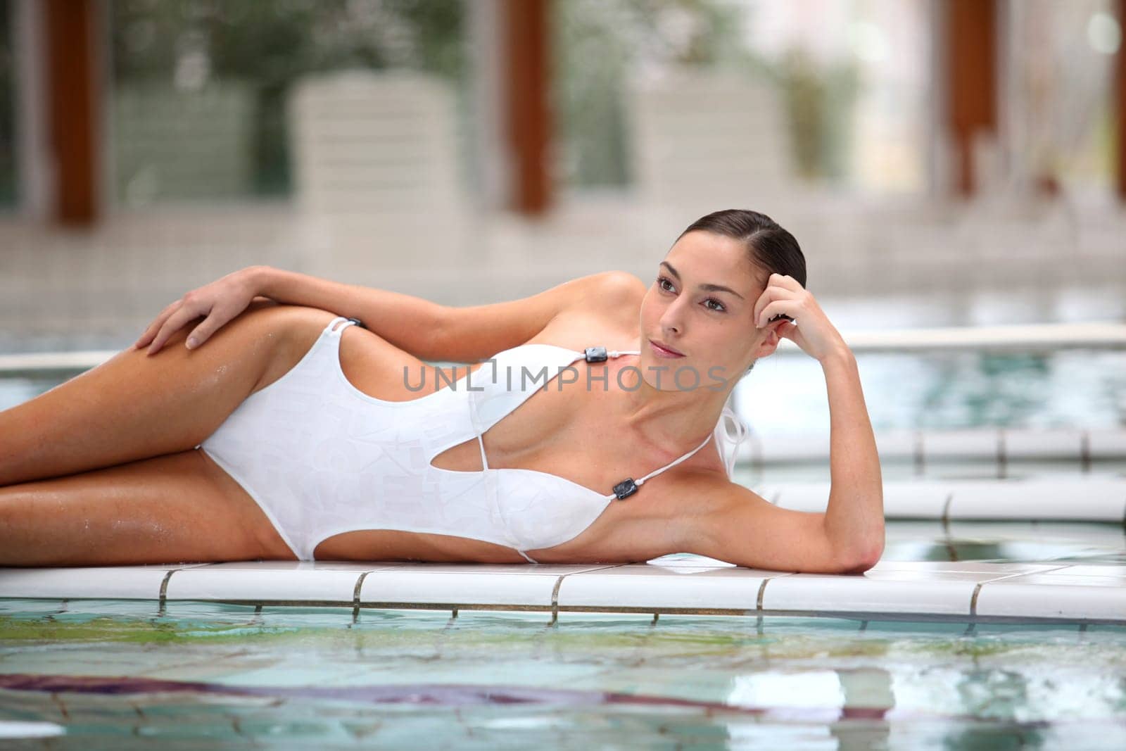 Beautiful woman laying by a thalassotherapy pool