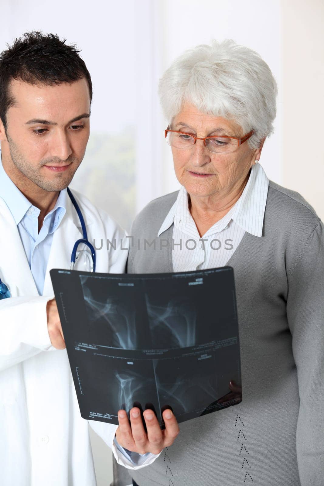 Doctor showing x-ray results to elderly woman