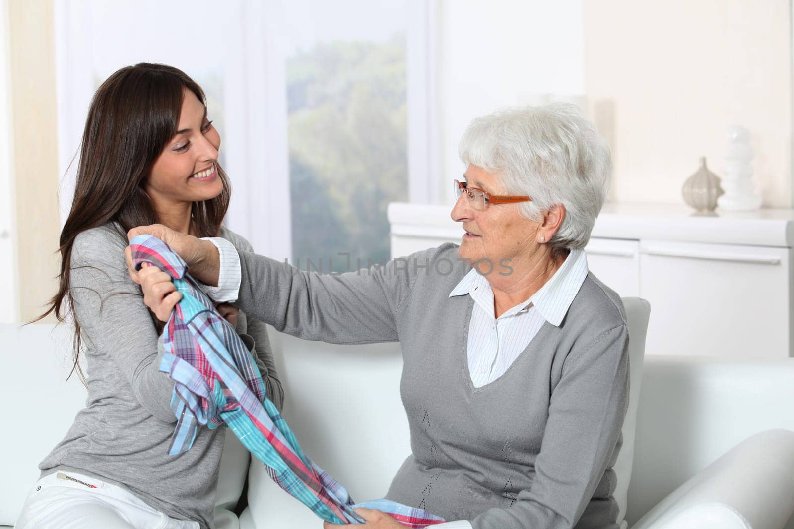 Young woman showing new clothes to grandmother