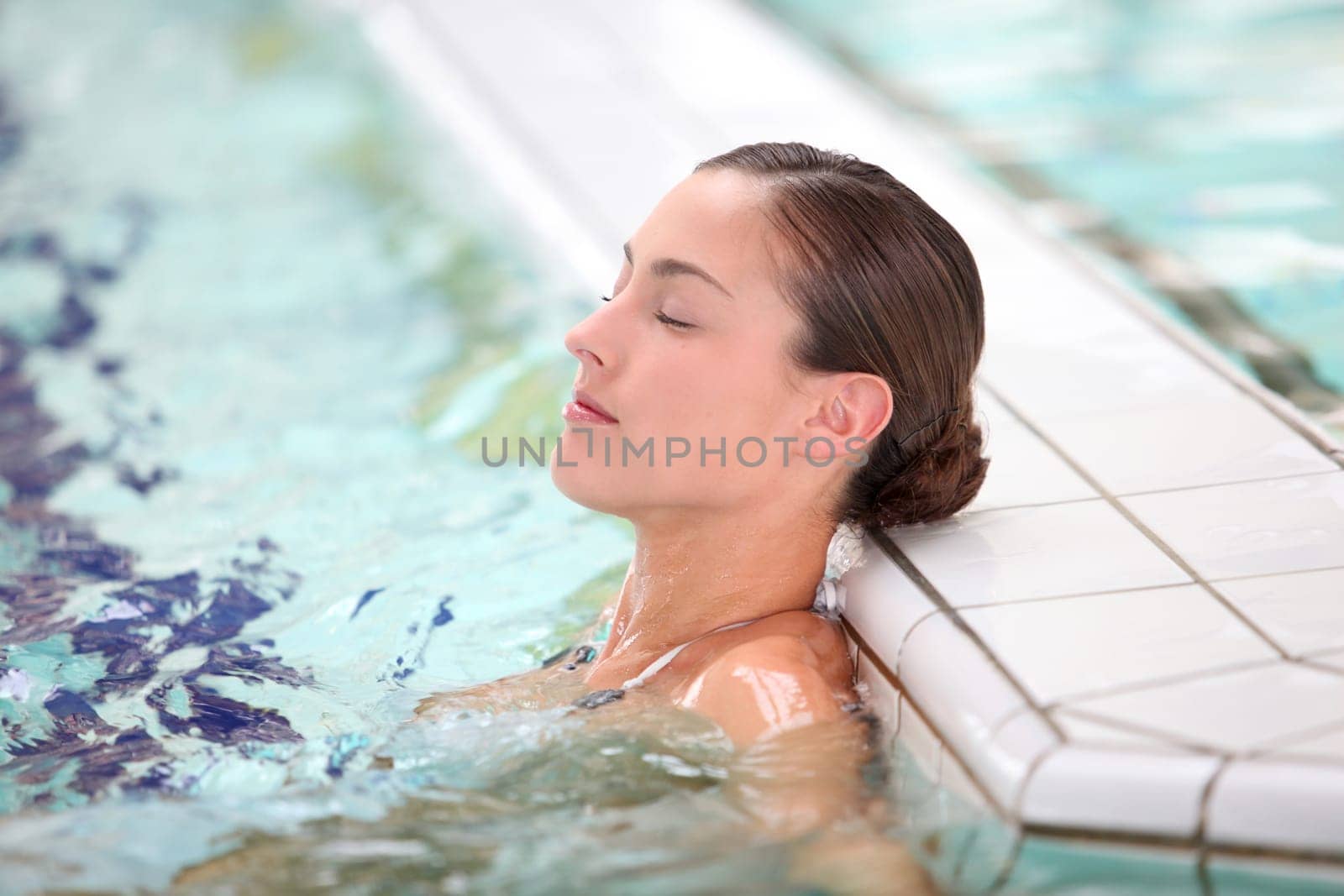 Beautiful young woman relaxing in seawater pool