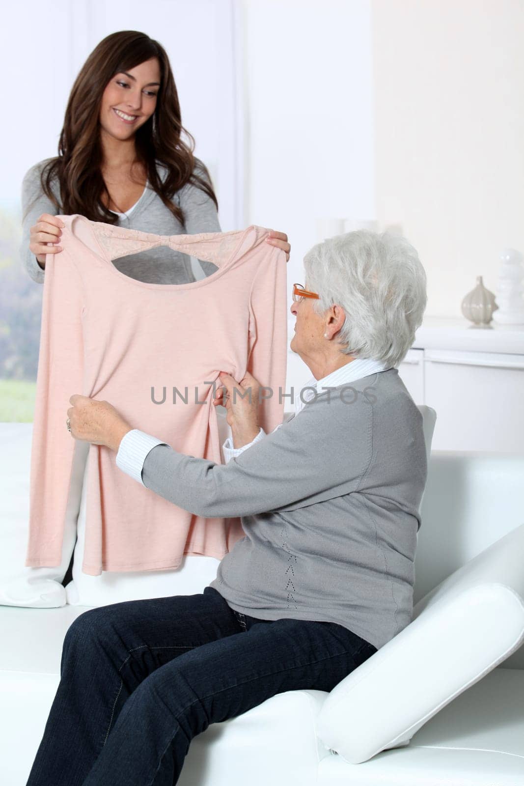 Young woman showing new clothes to grandmother