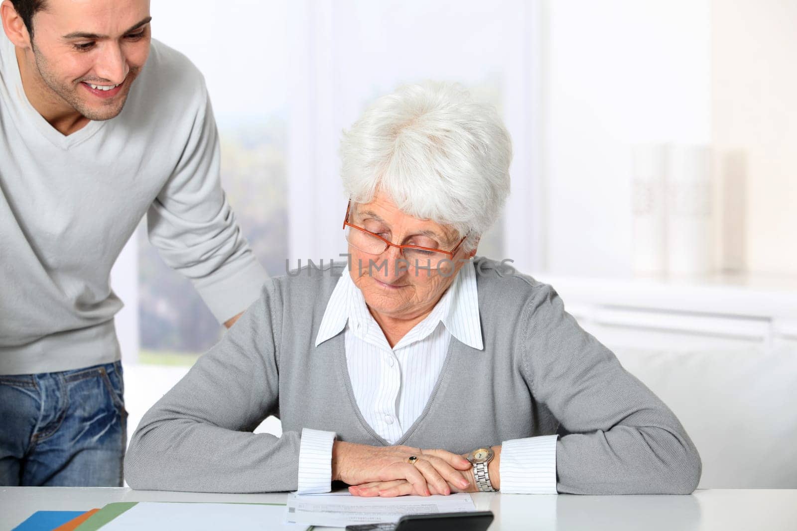 Young man helping elderly woman with paperwork