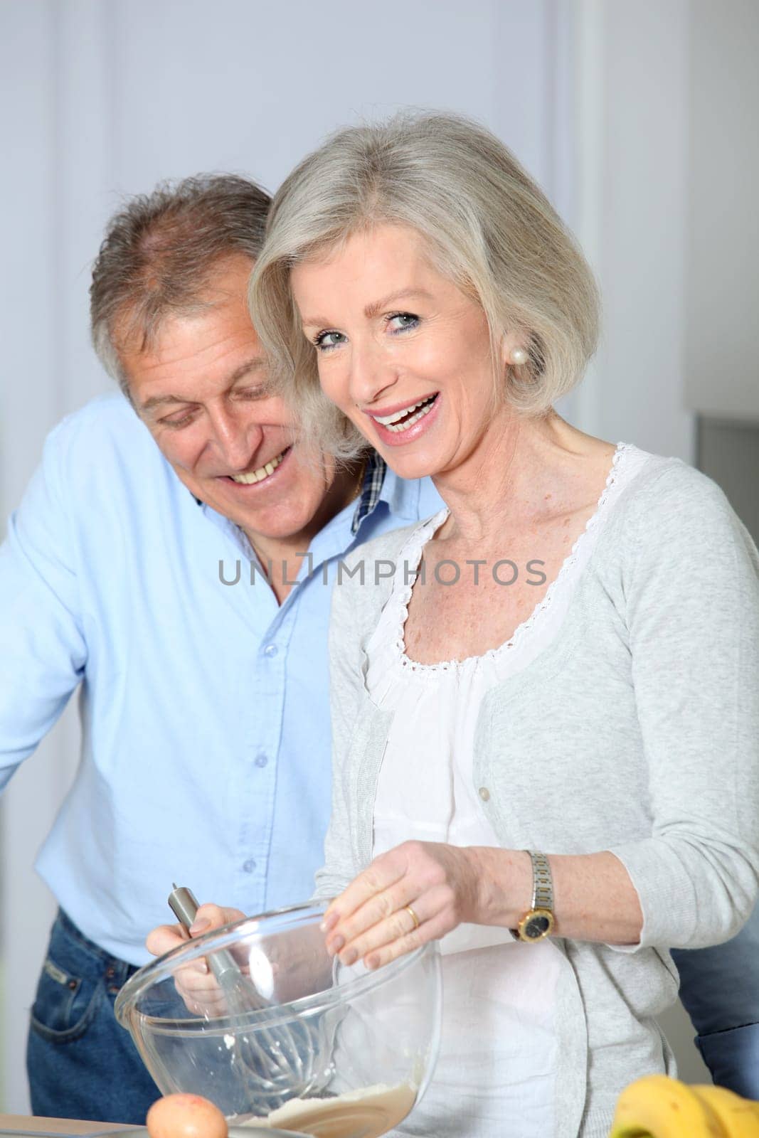 Senior couple in kitchen baking cake