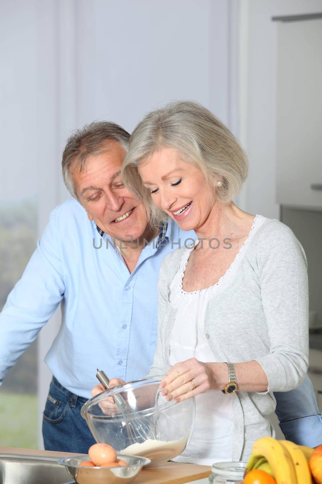 Senior couple in kitchen baking cake