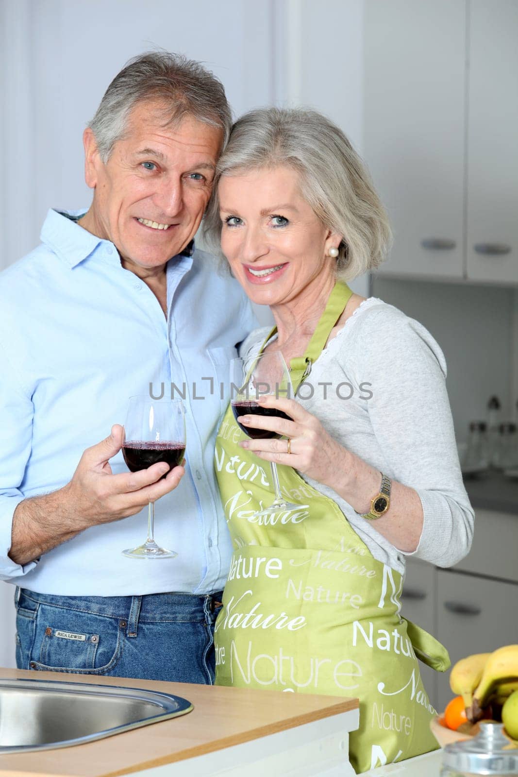 Senior couple drinking wine in kitchen