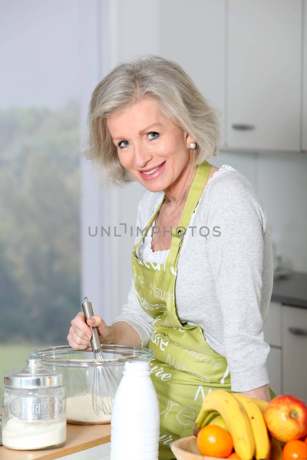 Closeup of smiling senior woman baking in kitchen