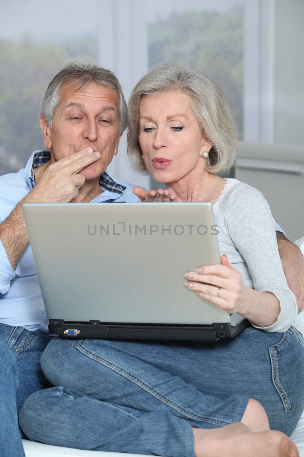 Senior couple waving at web camera
