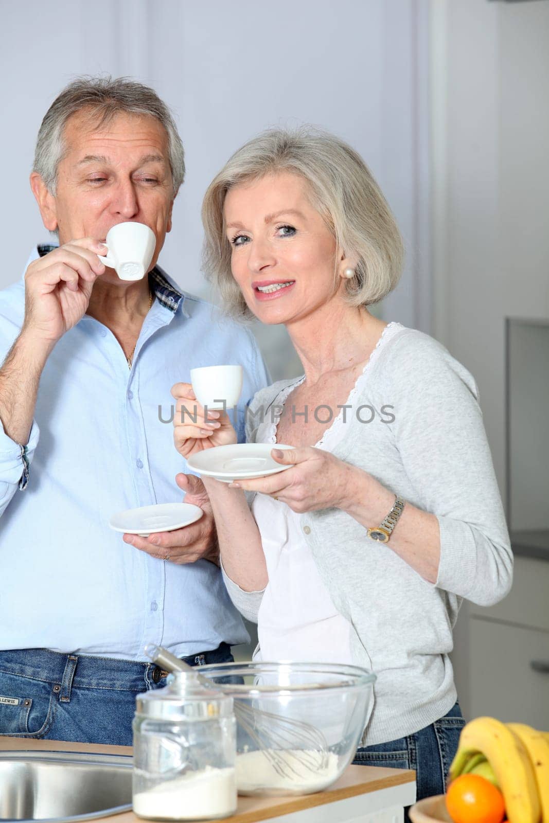 Senior couple taking coffee in kitchen