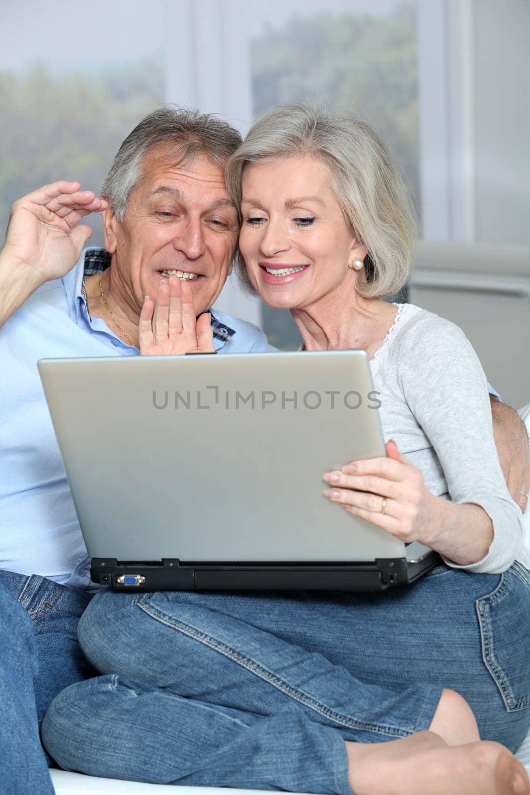 Senior couple waving at web camera