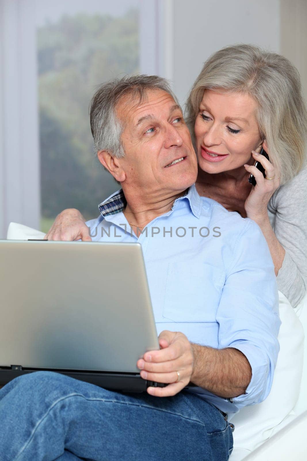 Senior couple at home surfing on internet