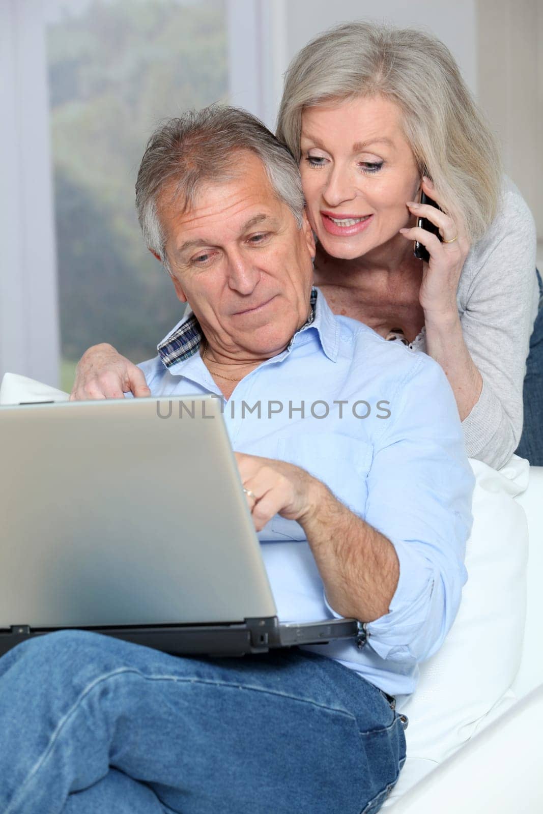 Senior couple at home surfing on internet