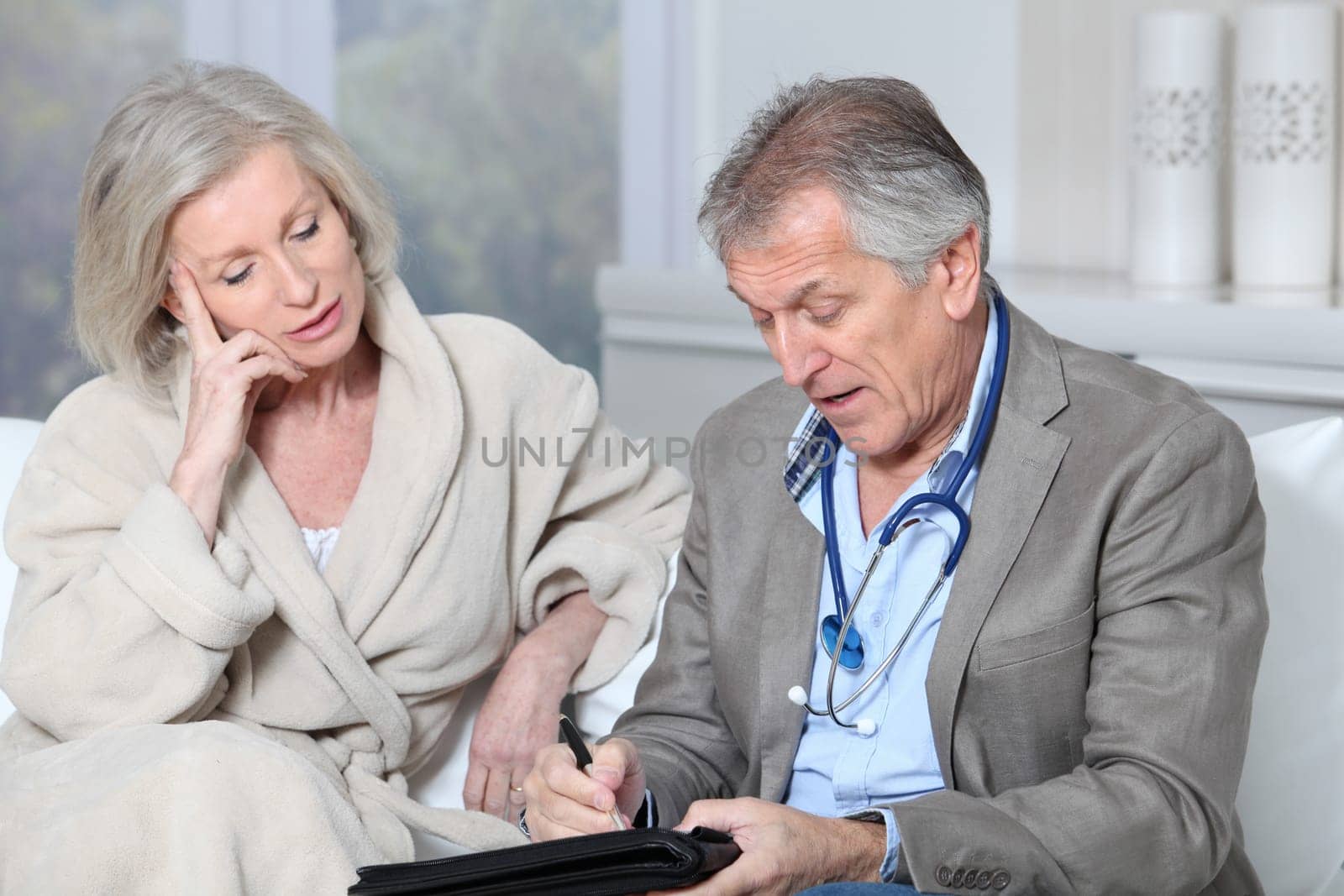 Doctor writing prescription to patient