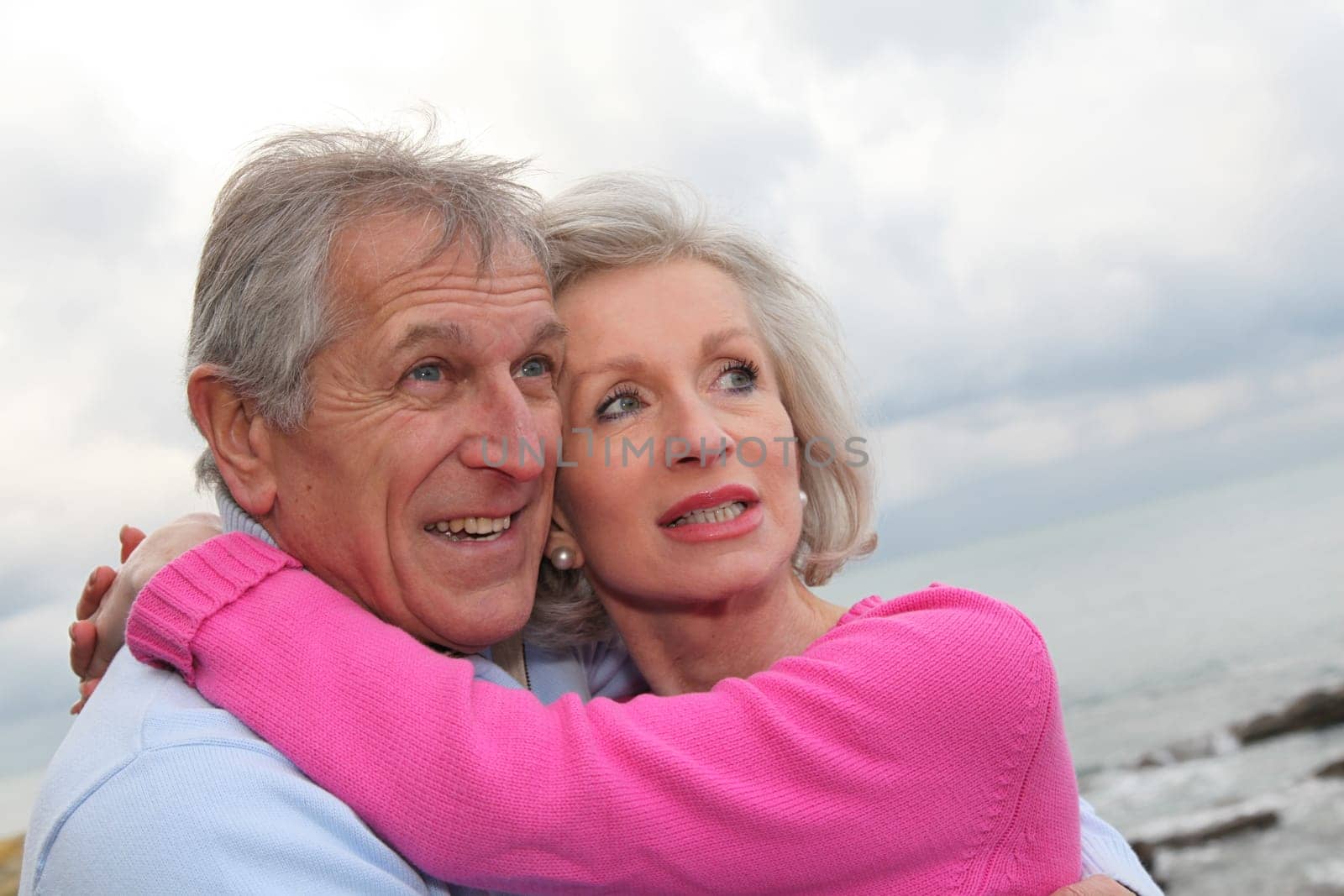 Happy senior couple embracing each other by the sea
