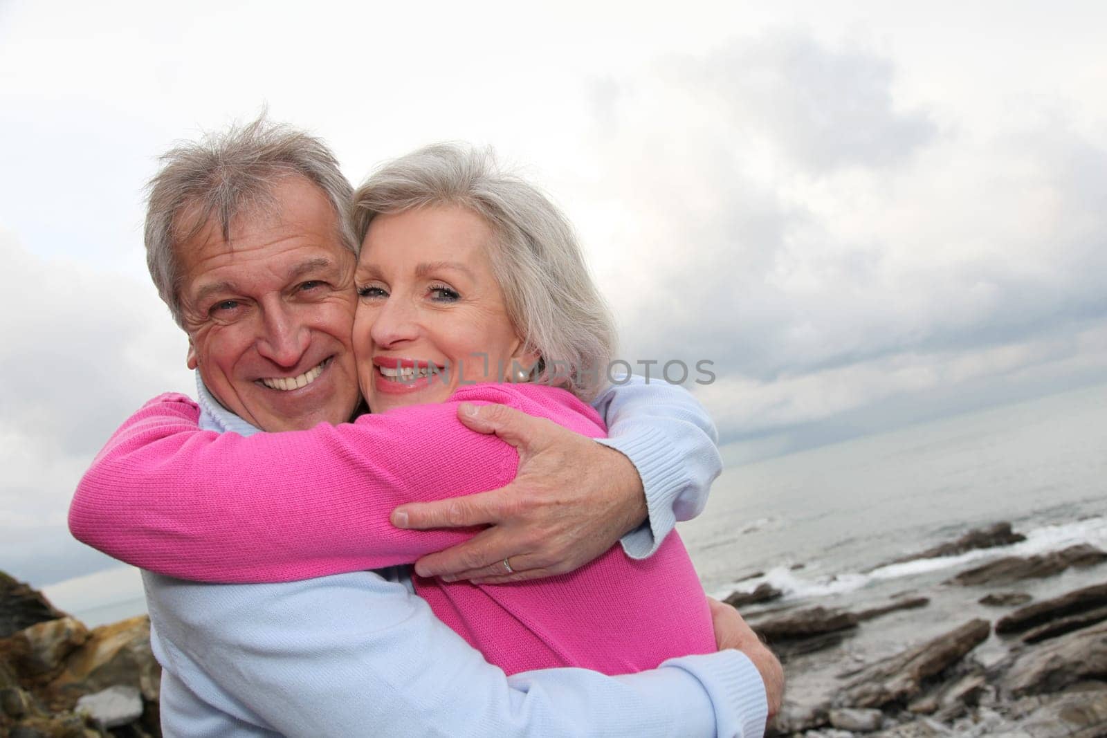 Happy senior couple embracing each other by the sea