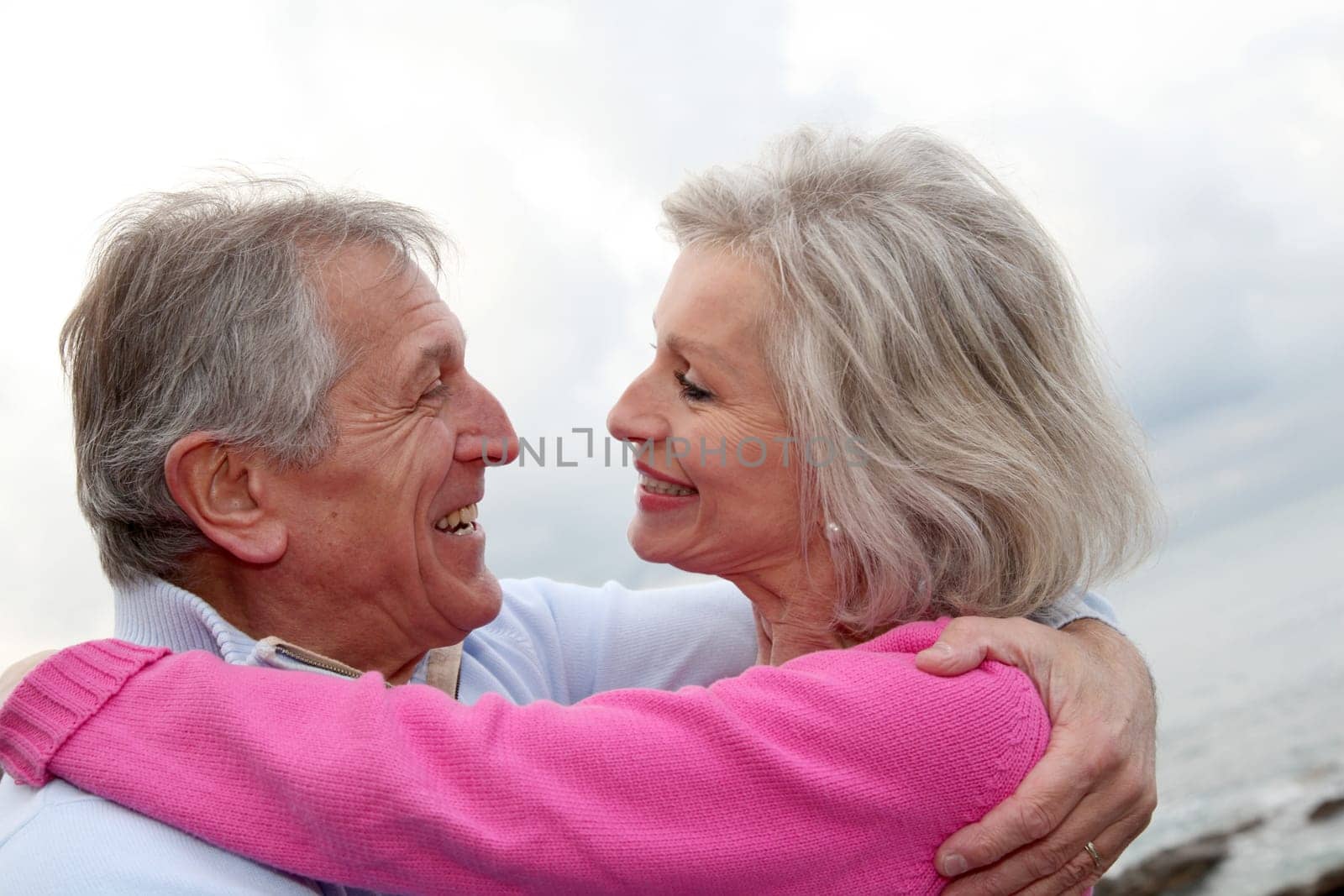 Happy senior couple embracing each other by the sea