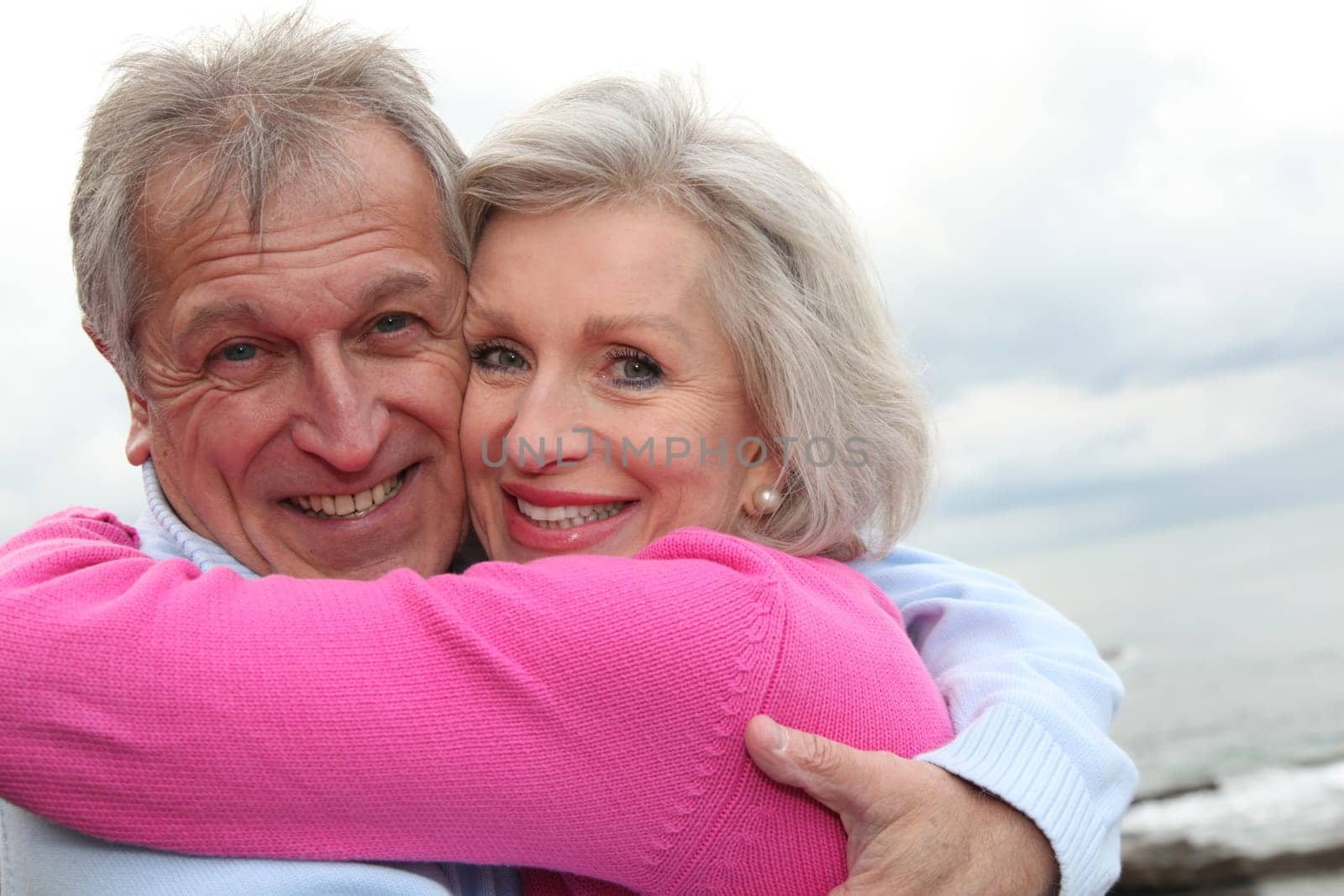 Happy senior couple embracing each other by the sea